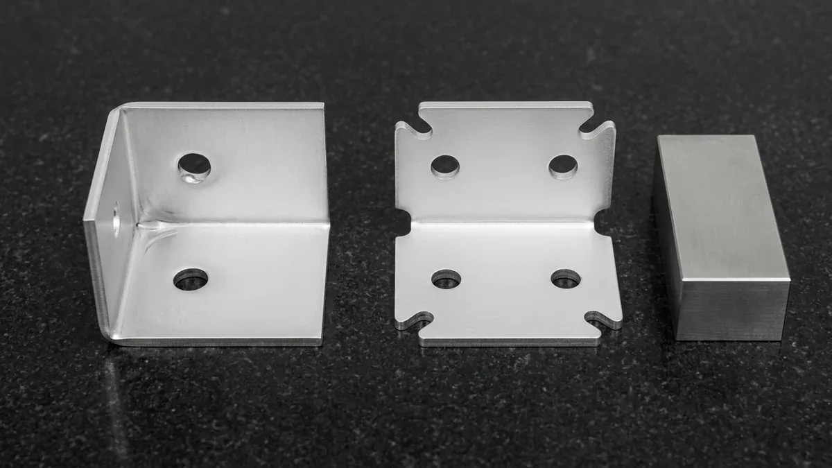 Sheet metal DFM comparison coupon showing corner bend relief notches preventing metal tearing and maintaining hole roundness