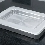 Precision CNC milled 6061-T6 aluminum pocket enclosure showing internal corner fillet radii flat on black granite plate