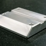 CNC-milled 6061-T6 aluminum structural guide block contrasting a 30-degree full-depth bevel ramp with 45-degree edge chamfers