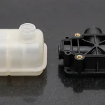 Translucent HDPE blow-molded expansion tank and black PA66-GF30 injection-molded pump manifold with knurled brass inserts