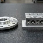 3-axis VMC milled 7075-T6 aluminum rotary flange beside 4-axis HMC machined 6061-T6 hydraulic manifold block
